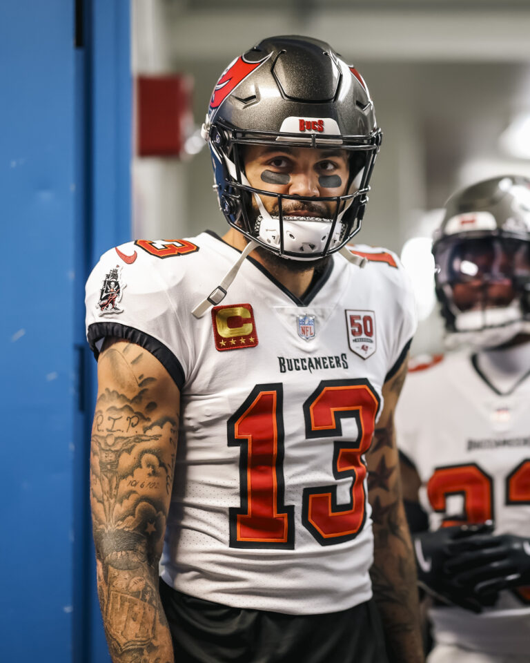 Buccaneers players in red and pewter jerseys, showcasing legends like Warren Sapp and Derrick Brooks in action during historic games.