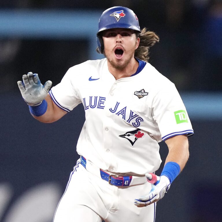 Addison Barger fielding a ground ball during a Toronto Blue Jays game, showcasing his strong arm and defensive skills.