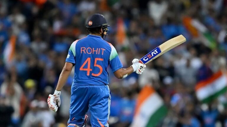 Rohit Sharma, Indian cricket captain, in blue jersey preparing to bat during an international match, displaying focus and leadership on the field.