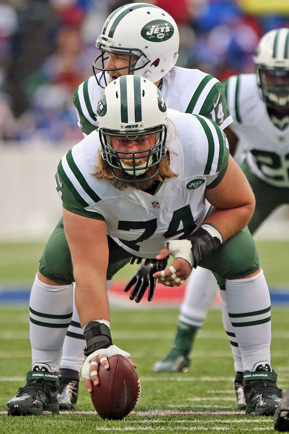 Nick Mangold, former New York Jets center, posing on the field in his team uniform during an NFL game.