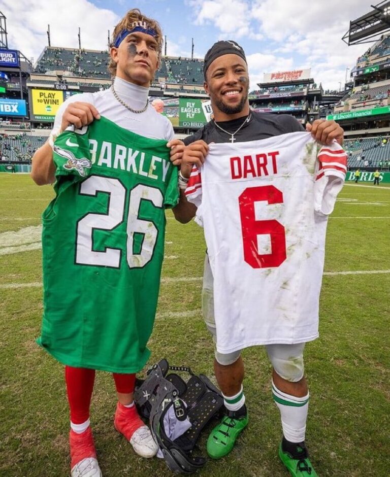 Giants quarterback throws a pass as two Eagles defenders approach during a high-stakes game